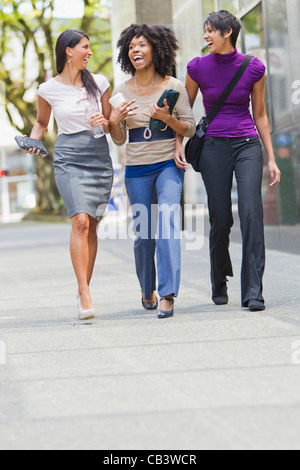 Trois businesswomen walking outside office Banque D'Images