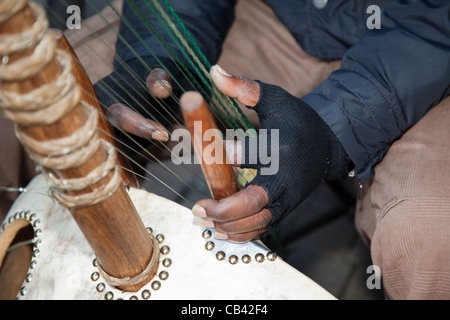 Jeu de Musican Chaîne africaine Kora, un luth à 21 cordes-bridge-harpe instrument , faite de 21 chaînes, de citrouilles, de cuir et de bois à Manchester, UK Banque D'Images
