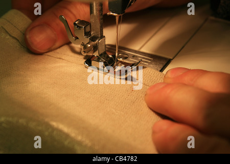 Détail de couture machine à coudre tan toile tenue par une main d'homme Banque D'Images