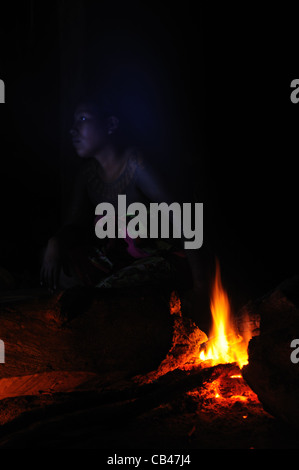 Femme indienne Embera derrière un feu de camp pendant la nuit dans la jungle à la communauté autochtone Embera Puru au Panama. Banque D'Images