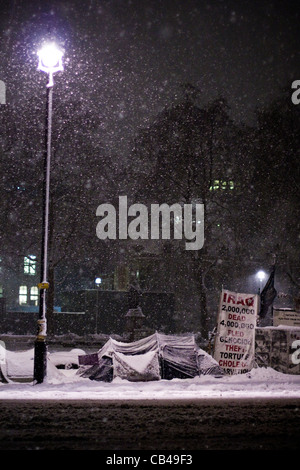 Londres : Des manifestants de la neige à l'extérieur du camping chambres du Parlement que la neige tombe sur la place du Parlement à Westminster, London, UK Banque D'Images