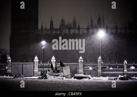 Londres : Des manifestants de la neige à l'extérieur du camping chambres du Parlement que la neige tombe sur la place du Parlement à Westminster, London, UK Banque D'Images