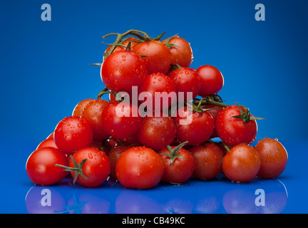 Pile de tomate cerise sur fond bleu Banque D'Images