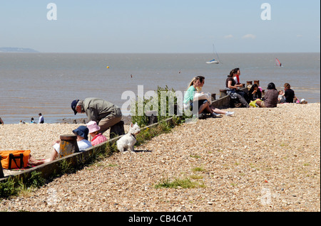 Les touristes assis sur un sol en bois à l'aine à Whitstable Kent, Angleterre Banque D'Images