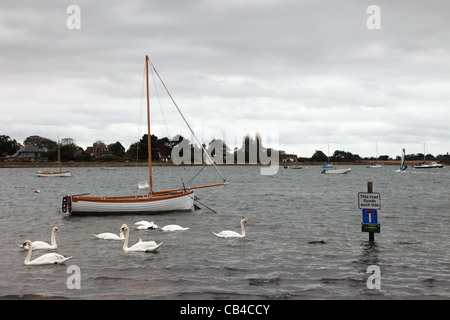 Bateau à voile cygnes et les inondations de la route chaque marée signer Bosham Chichester Harbour West Sussex Banque D'Images