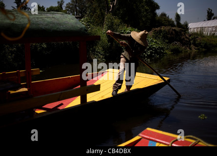 Un homme utilise un bateau à travers le canal de Xochimilco, au sud de Mexico City Banque D'Images