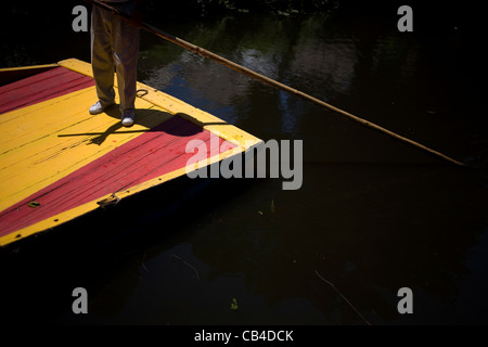 Un homme utilise un bateau à travers le canal de Xochimilco, au sud de Mexico City Banque D'Images