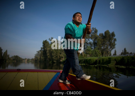 Un homme utilise un bateau à travers le canal de Xochimilco, au sud de Mexico City Banque D'Images