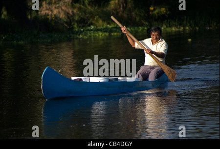 Un homme utilise un bateau à travers le canal de Xochimilco, au sud de Mexico City Banque D'Images