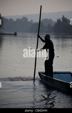 Un homme utilise un bateau à travers le canal de Xochimilco, au sud de Mexico City Banque D'Images