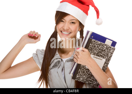 Écolière asiatique wearing red Santa Claus hat holding cahier et portables Banque D'Images