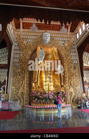 Jeune fille à côté de la statue de Bouddha géant au temple bouddhiste de Dhammikarama, Penang, Malaisie, en Asie du sud-est Banque D'Images