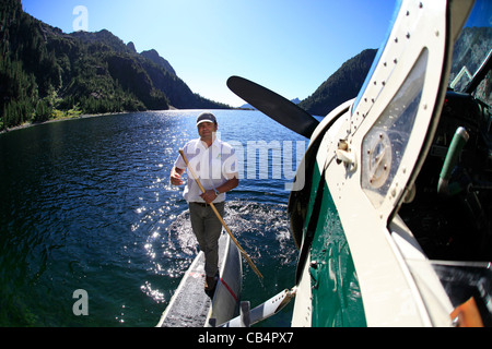 Un pilote d'hydravion de Havilland Beaver colporte son à la rive d'un lac de montagne dans l'île de Vancouver Banque D'Images