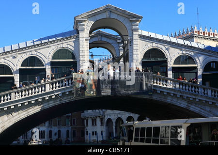 Une épouse qui s'est perché sur le parapet du Pont du Rialto à Venise, l'Italie, pour une photo avec son époux. Banque D'Images