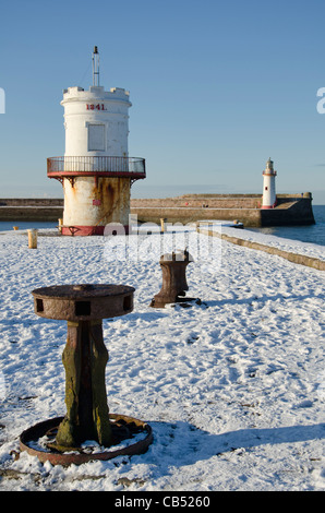 Whitehaven jetée nord dans la neige, avec le West Pier dans l'arrière-plan Banque D'Images