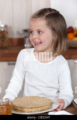 Little girl holding a plate of crêpes Banque D'Images