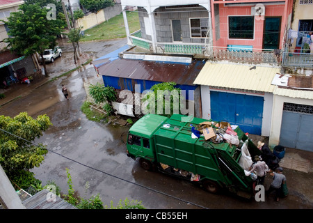 Les hommes sont le chargement d'un camion à ordures avec corbeille de rue d'une ville dans la province de Kampong Cham, au Cambodge. Banque D'Images