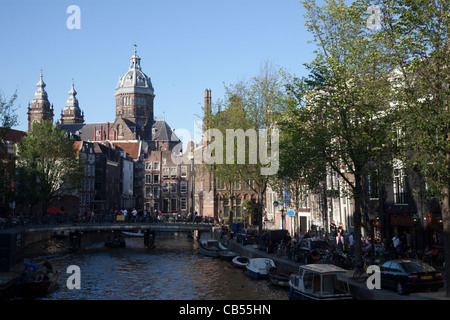 Vue d'un canal avec Sint-Nicolaaskerk en arrière-plan. Amsterdam, Pays-Bas. Banque D'Images