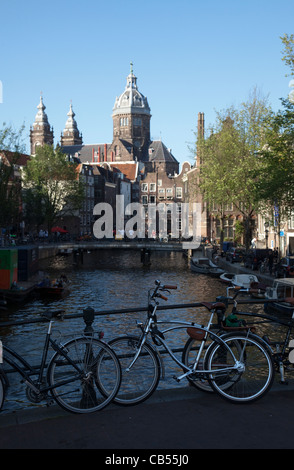 Vue d'un canal avec Sint-Nicolaaskerk en arrière-plan. Amsterdam, Pays-Bas. Banque D'Images