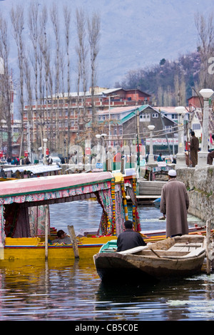 Scène quotidienne de la vie du lac Dal, Srinagar, Cachemire, Inde, avec des bateaux de campagne locaux de Kashmiris et shikara près du ferry. Banque D'Images