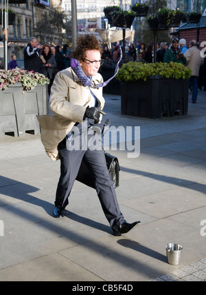 "L'homme pressé" - Artiste stationnaire immobile sur les rues de la ville, avec porte-documents et des taux élevés d'égalité se raidit, Manchester UK Banque D'Images