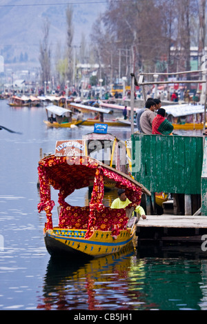 Scène depuis le ferry du lac Dal, Srinagar, Cachemire, Inde, avec Shikaras, villageois et touristes. Banque D'Images