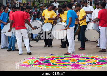 Rangoli design et batteurs dans une rue indienne pendant le festival hindou le Dasara. Puttaparthi, Andhra Pradesh, Inde Banque D'Images