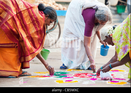 Les femmes de l'Inde faisant un rangoli indien design dans un festival de rue. Puttaparthi, Andhra Pradesh, Inde Banque D'Images