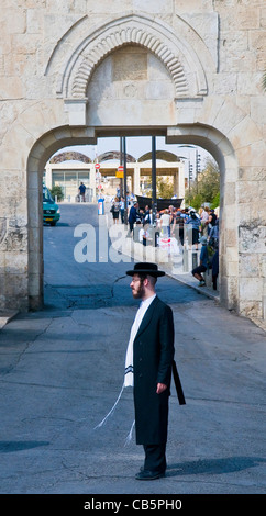 Un homme juif orthodoxe ultra- se tenir près de la porte du fumier dans la vieille ville de Jérusalem, Israël Banque D'Images