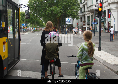 Scène de rue à Berlin. Une femme et deux enfants sur les vélos. Kurfürstendamm, Berlin, Allemagne. Banque D'Images