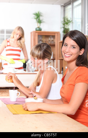 Les jeunes femmes prenant le petit déjeuner avec eux Banque D'Images