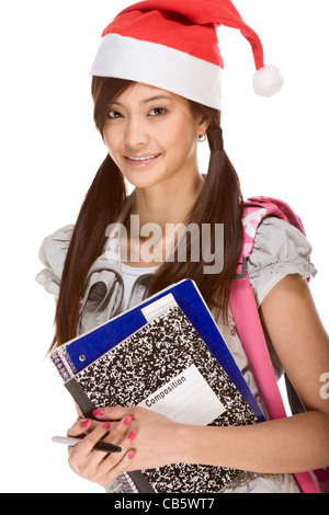 Écolière asiatique wearing red Santa Claus hat avec sac à dos Composition de portefeuille d'adresses, bloc-notes et stylo Banque D'Images