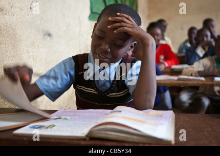 Les enfants à leur bureau en classe pendant un cours. Une ONG exécute divers programmes de formation pour aider l'école et les élèves. Banque D'Images