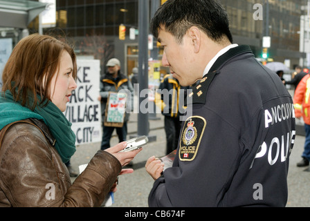 Le chef de la Police de Vancouver, Jim Chu de donner une interview à un journaliste de la rue. Banque D'Images