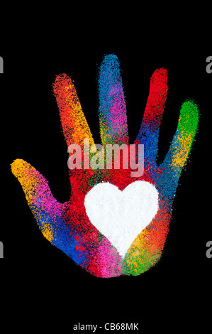 Childs hand print multicolore avec un cœur blanc fait avec de la poudre de couleur sur fond noir Banque D'Images