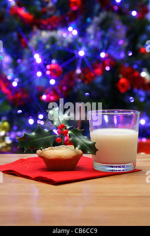 Photo d'un verre de lait et d'un hachis parmentier de houx sur haut sur une table, laissé de côté la veille de Noël pour le Père Noël, Banque D'Images