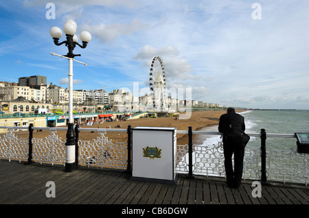 L'homme regardant la plage de la jetée de Brighton - Angleterre Banque D'Images