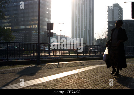 Vue vers le soleil de la partie de l'éléphant et Château à Londres avec une femme marche dans l'avant-plan Banque D'Images