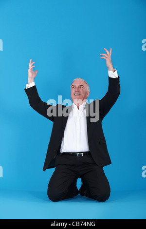 Homme d'affaires sur ses genoux Banque D'Images
