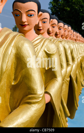 Une ligne de vie statues grandeur nature de bouddha dévots en or robes sont alignés dans une rangée à Tachileik pagode Shwe Dagon au Myanmar Banque D'Images