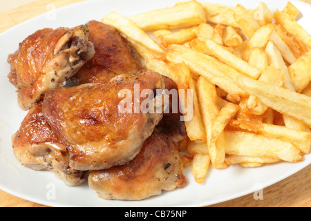 Un plat de service empilé avec citron et de cuisses de poulet rôti frites, ou des jetons Banque D'Images