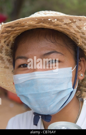 Femme khmère dans un masque chirurgical lors d'une fête de village, nouvel an cambodgien (Chaul Chnam Thmey), Bakong Village, Siem Reap, Cambodge Banque D'Images