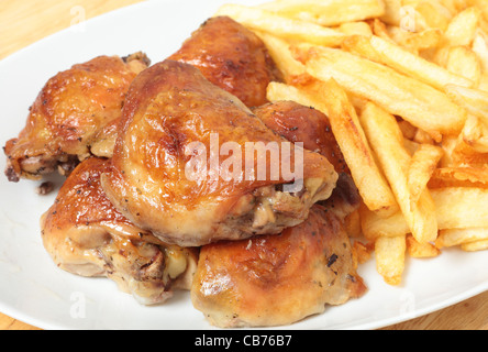 Un plat de service empilé avec citron et de cuisses de poulet rôti frites, ou des jetons Banque D'Images