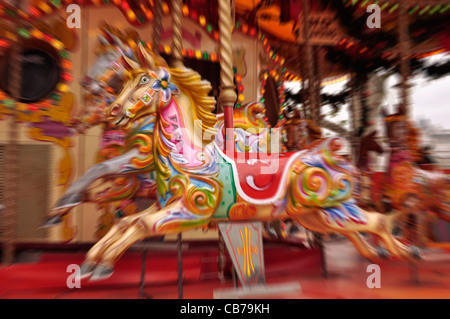 Carrousel traditionnel peint de couleurs vives, ride, avec les chevaux se déplaçant à Banque D'Images