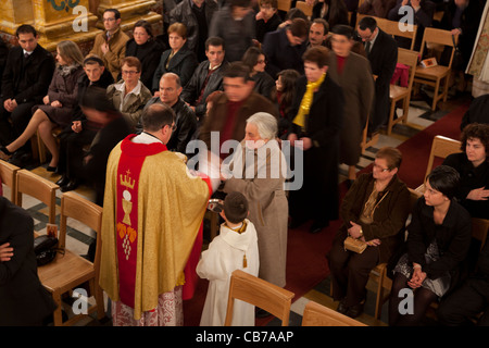 Les dévots recevoir la sainte communion à la messe dans l'église paroissiale de Xaghra à Gozo à Malte. Banque D'Images