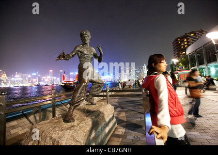 Des touristes posent pour des photos de nuit en face de la statue de bruce lee sur l'avenue of Stars, Kowloon Hong Kong, Hong Kong, Chine Banque D'Images