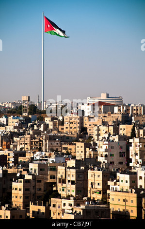 Vue de la ville de Amman avec drapeau jordanien géant et ciel bleu en arrière-plan Banque D'Images