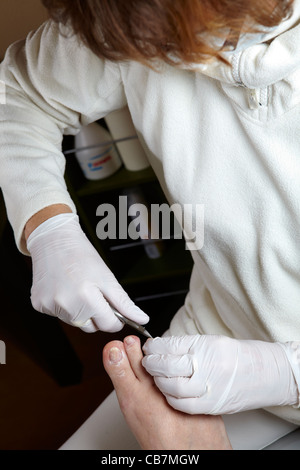 Un podiatre couper les ongles des pieds d'une femme Banque D'Images