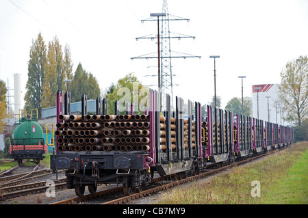 La compagnie allemande les wagons chargés à plat avec des tuyaux d'acier, Düsseldorf, Allemagne. Banque D'Images