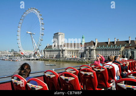 Bus touristique à toit ouvert ciel bleu jour de printemps ensoleillé pour les touristes traversent Westminster Bridge vues à marée haute de la Tamise et London Eye Angleterre Royaume-Uni Banque D'Images